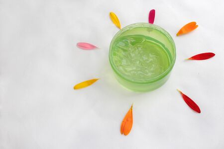Jar of cream and flowers on white background, top view. Professional cosmetic productsの写真素材