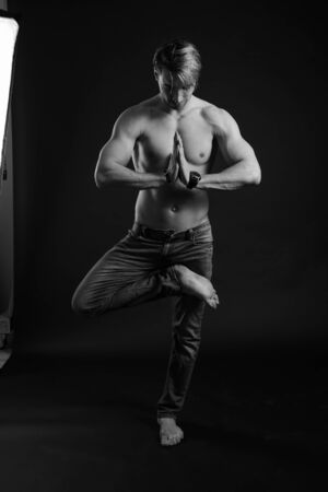black and white studio shoot of strong athletic man on dark background. sexy bodyの写真素材