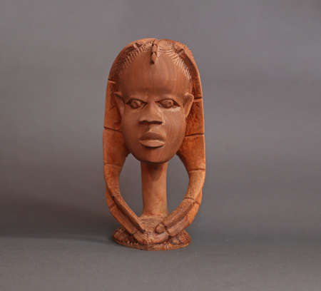 Wooden brown statue of a womans head with pigtails. isolated on gray backgroundの写真素材