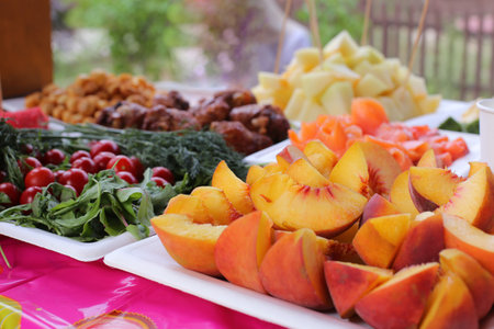 Fruit mix. Peach, grapes, Pieces of fruit on a plate lie on a white wooden background. Copy space, space for text.の写真素材