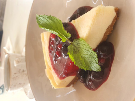 Piece of cheesecake with fresh strawberries and mint isolated on white plateの写真素材