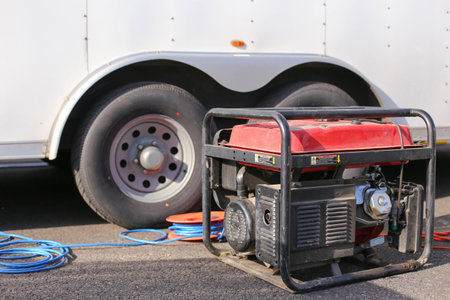 Gasoline powered portable generator standing next to a white carの写真素材