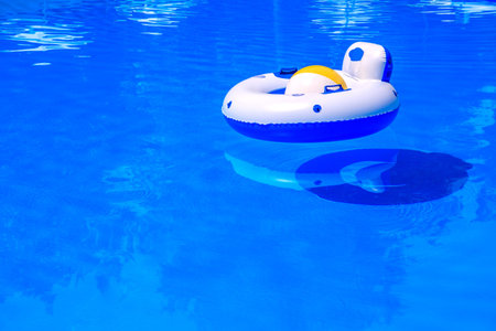 Ball and life ring in the pool with blue water