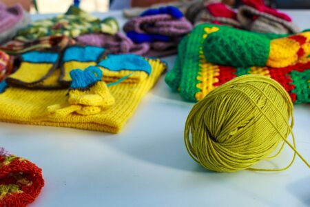 A tangle of woolen threads for knitting against the background of knitted clothesの写真素材