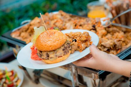 plate with burger and pilaf in handの写真素材