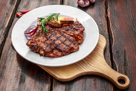 A large steak with spices and vegetables on the grillの写真素材