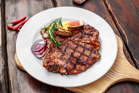 A large steak with spices and vegetables on the grillの写真素材