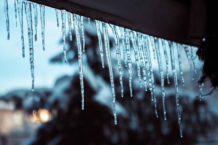 icicles hanging from the roof in cold weatherの写真素材