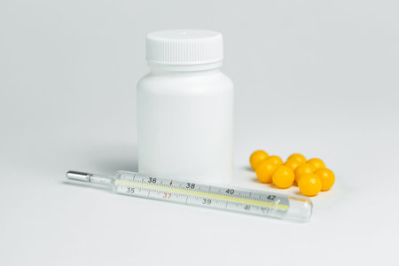 white plastic can with medicines and thermometer