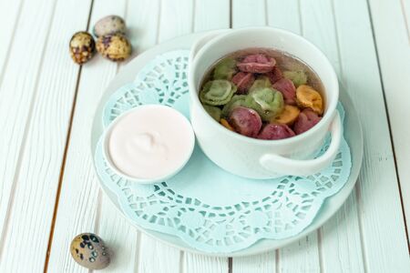 rainbow dumplings for children on a wooden background with flowers and quail eggsの写真素材