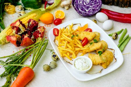 Breaded chicken with French fries and sauceの写真素材