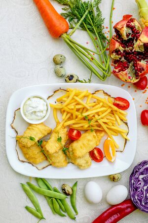 Breaded chicken with French fries and sauceの写真素材