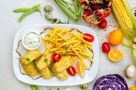 Breaded chicken with French fries and sauceの写真素材