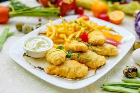 Breaded chicken with French fries and sauceの写真素材