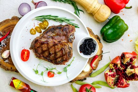 juicy barbecue steak with pickled onions and jalapeno on a white plateの写真素材