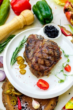 juicy barbecue steak with pickled onions and jalapeno on a white plateの写真素材