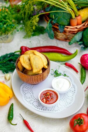 pies with meat in wooden utensils with sauces on a white plateの写真素材