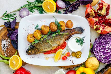 Grilled trout with potato sauce and tomato sauce and jalapenoの写真素材