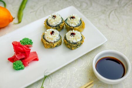 fried warm sushi with wasabi and soy sauce with chopsticksの写真素材