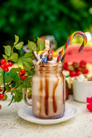 Crazy shake on top with marshmallow, waffles, biscuits and sweets on a bright colored backgroundの写真素材