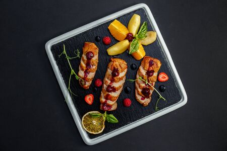 smoked chicken on a dark plateの写真素材