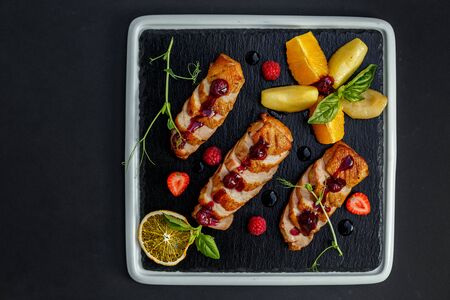 smoked chicken on a dark plateの写真素材