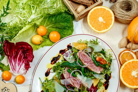 salad with smoked meat and ingredients served on the tableの写真素材