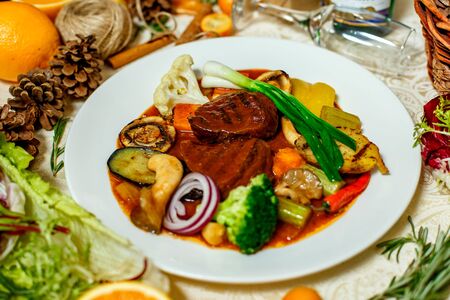 juicy steaks with grilled broccoli vegetables and mushrooms served on the tableの写真素材