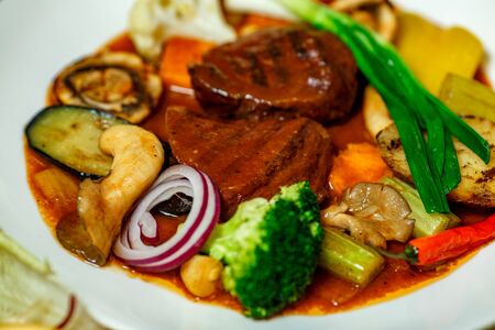 juicy steaks with grilled broccoli vegetables and mushrooms served on the tableの写真素材
