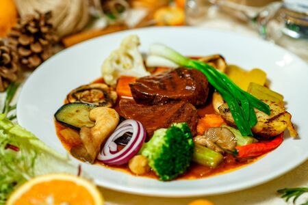 juicy steaks with grilled broccoli vegetables and mushrooms served on the tableの写真素材