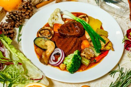 juicy steaks with grilled broccoli vegetables and mushrooms served on the tableの写真素材