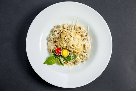 macaroni with mushrooms and cheese, with quail egg and tomato in cream sauce, isolatedの写真素材