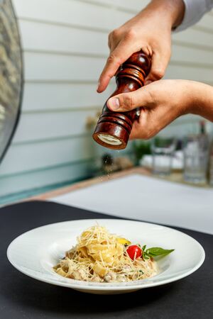 macaroni with mushrooms and cheese, with quail egg and tomato in cream sauce, isolatedの写真素材