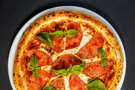 hot italian pizza with cheese and basil, isolatedの写真素材