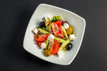 fresh greek salad with tomatoes, feta cheese, onions, olives and cucumbers, healthy food, isolatedの写真素材