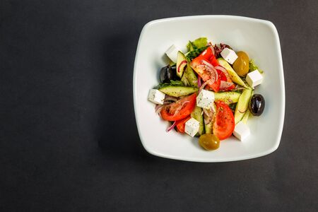 fresh greek salad with tomatoes, feta cheese, onions, olives and cucumbers, healthy food, isolatedの写真素材
