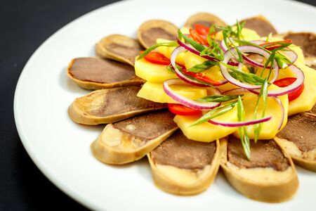 Kazakh cuisine, meat with boiled potatoes onions and herbs, on a white plateの写真素材