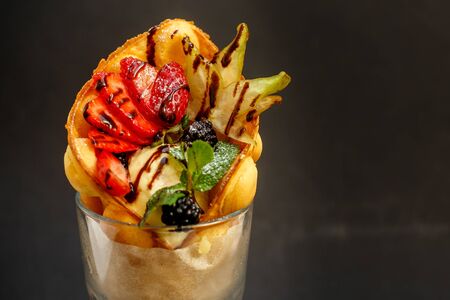 ice cream in a cup with waffles, mint and berriesの写真素材