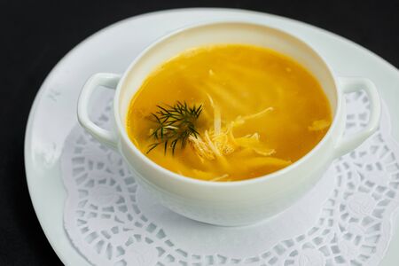 hot noodle soup with chicken and broth on a white plateの写真素材