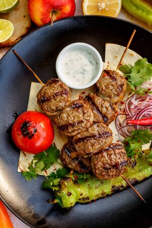 kebab with pita bread and grilled vegetables on a decorated tableの写真素材