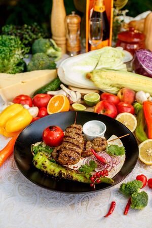 kebab with pita bread and grilled vegetables on a decorated tableの写真素材