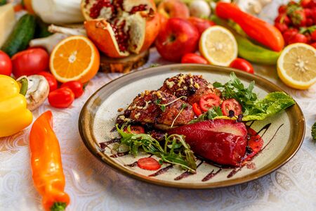 chicken thighs with rucola, nuts and vegetables on a decorated tableの写真素材