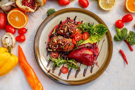 chicken thighs with rucola, nuts and vegetables on a decorated tableの写真素材