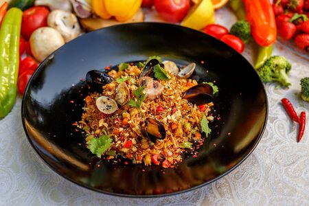 risotto rice with seafood, octopus mussels and vegetables with sauces on the decorated tableの写真素材