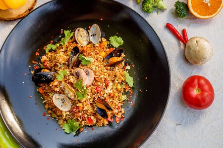 risotto rice with seafood, octopus mussels and vegetables with sauces on the decorated tableの写真素材