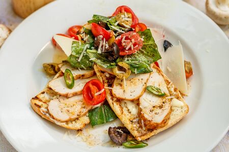 panini with chicken and vegetables on a plate on a decorated tableの写真素材
