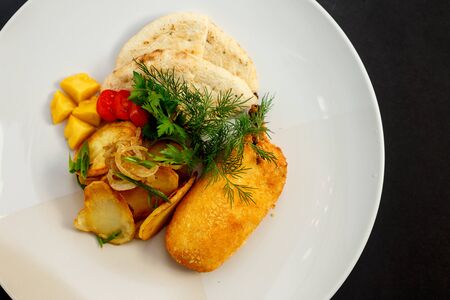 chicken leg breaded with pita potatoes and vegetablesの写真素材