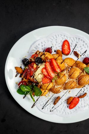 Waffles - a ball of Italian ice cream with berries and nuts and fresh fruitの写真素材