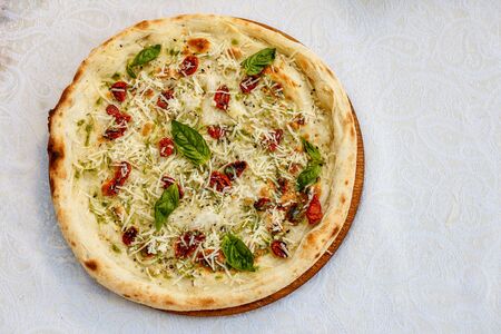 Italian focaccia bread with rosemary, basil and cheese on decorated tableの写真素材