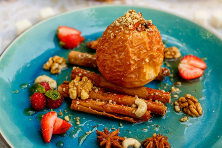 dessert, baked apple with nuts and berries on a decorated tableの写真素材